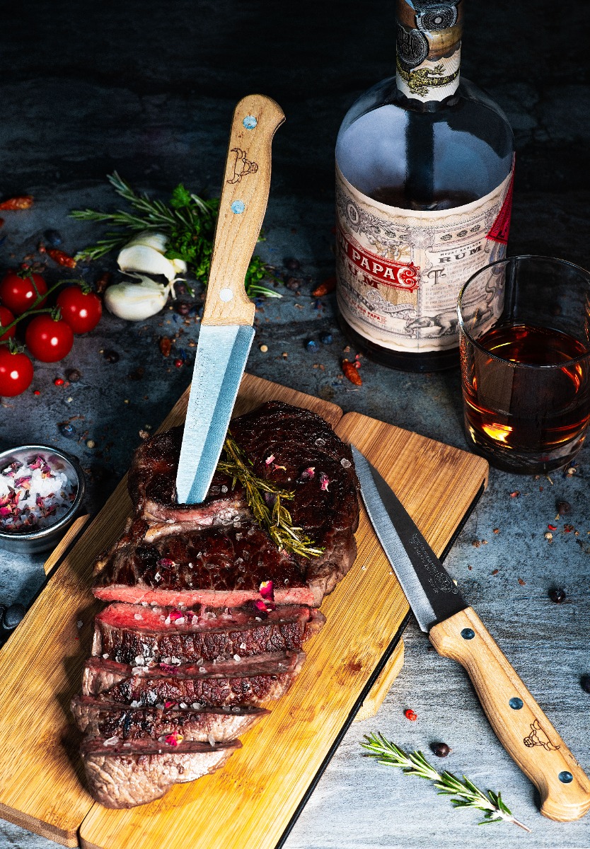 Faltbares Bambusbrett mit zwei Messern, dargestellt mit Fleisch.