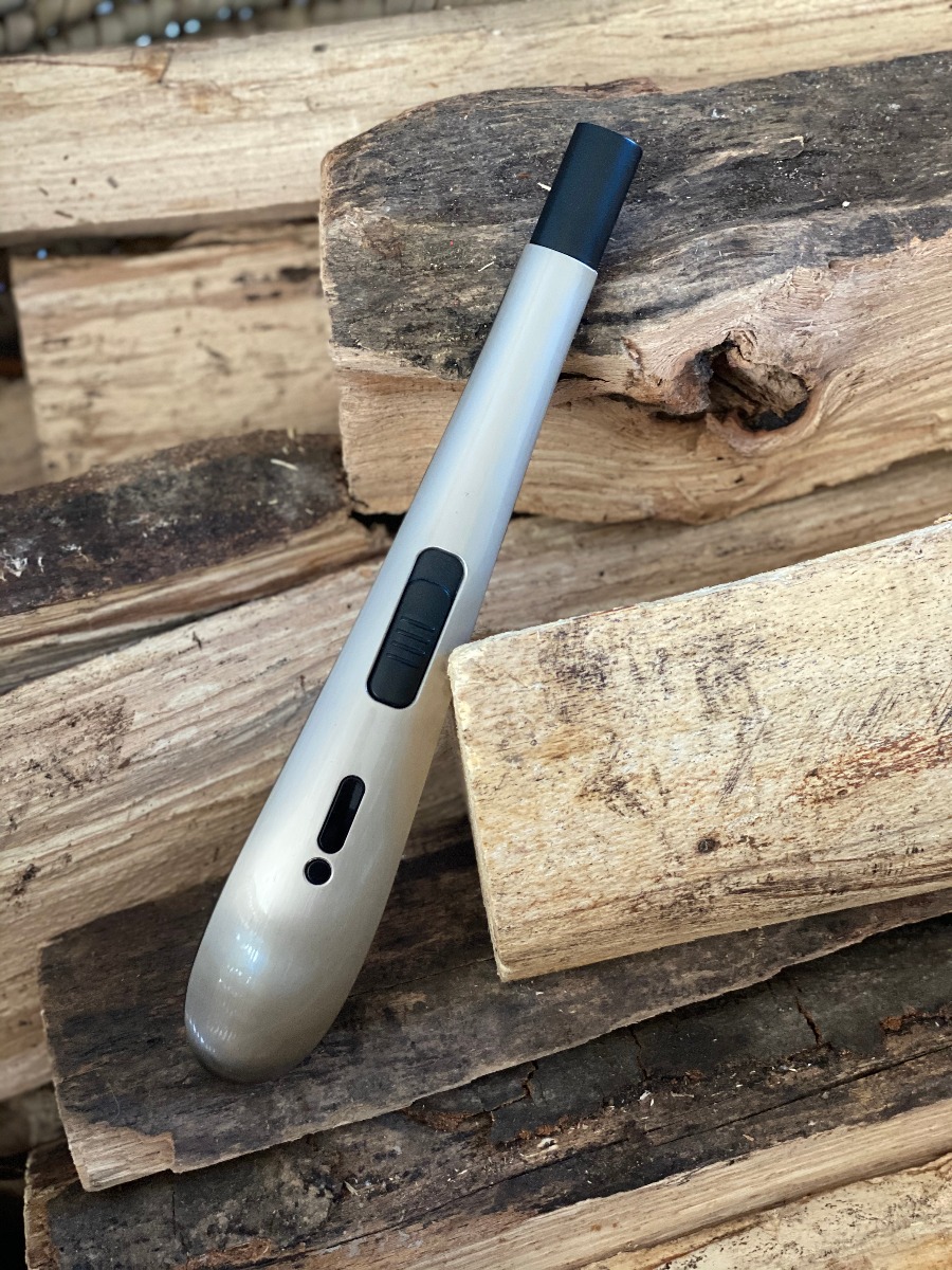 Wiederaufladbares Lichtbogen-Stabfeuerzeug mit USB-Kabel, dargestellt auf Holz.