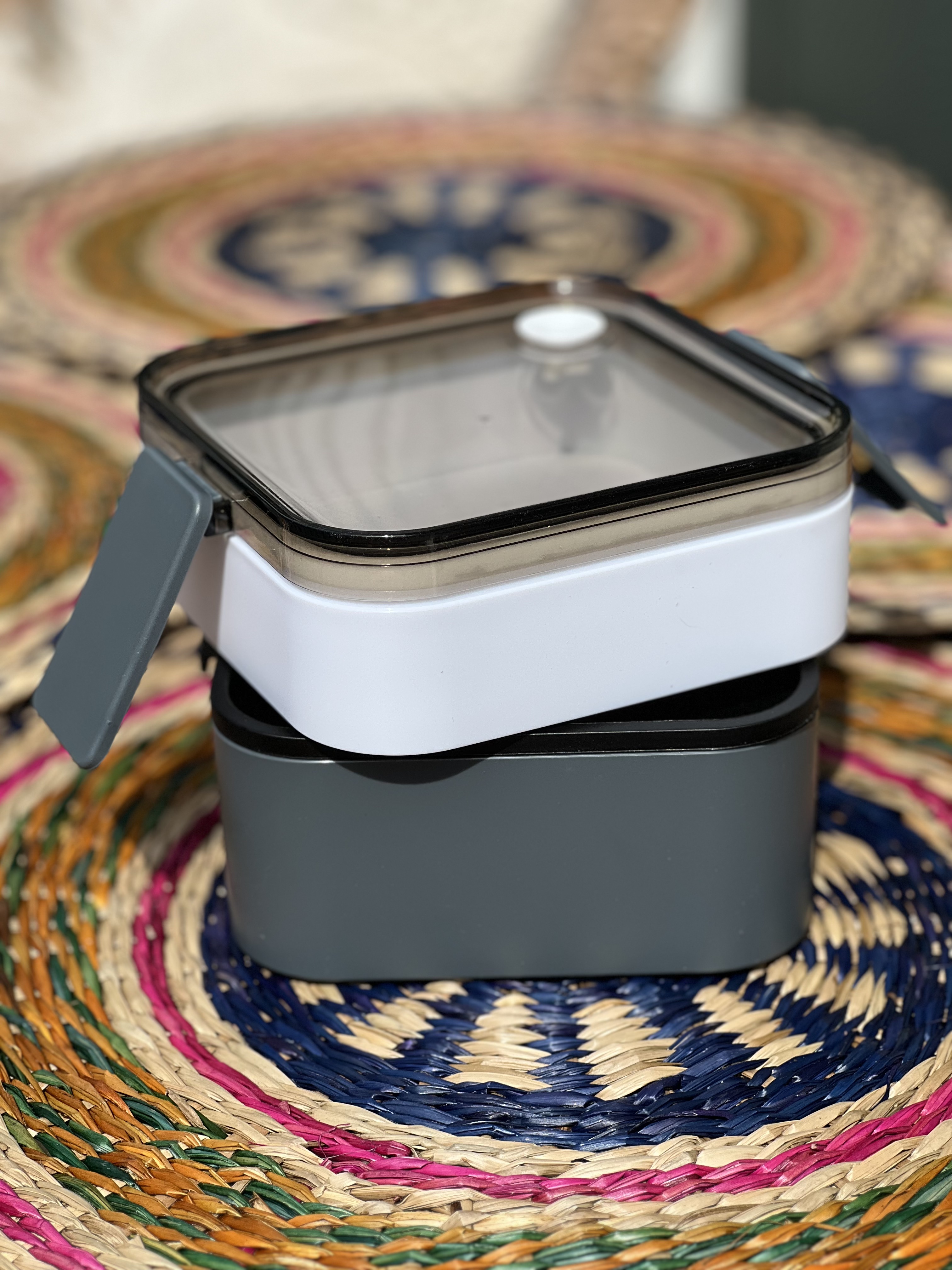 Quadratische Doppel-Lunchbox in gtau und weiss,leicht geöffnet dargestellt.