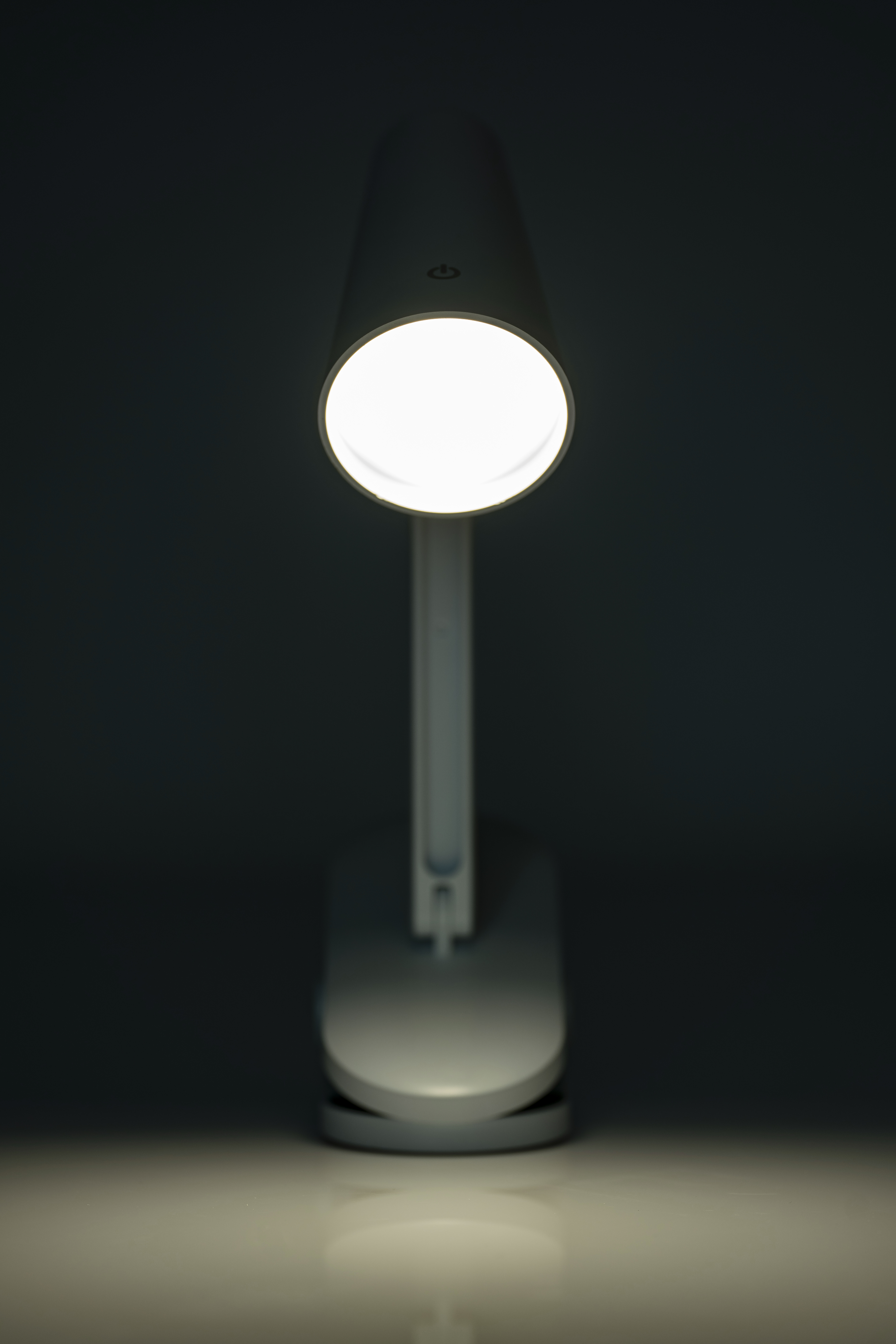 Klemmleuchte in weiß, dimmbar mit drei Lichtfarben, die leuchtend dargestellt ist.