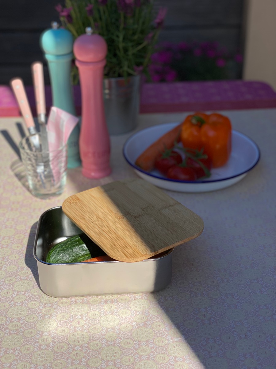 Ökologische Edelstahl-Lunchbox mit Bambusdeckel, halb geöffnet auf einem Tisch stehend.